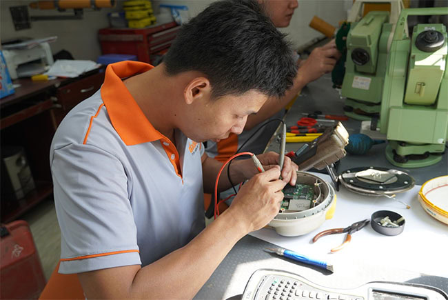 Chuyên viên kỹ thuật tại Trung tâm Kiểm định - Sửa chữa máy đo đạc EKTECH đang kiểm tra và sửa máy định vị GNSS cho khách hàng.