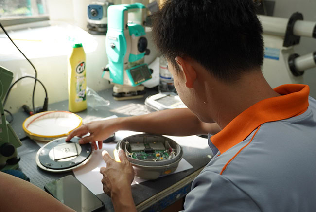 Chuyên viên kỹ thuật tại Trung tâm Kiểm định - Sửa chữa máy đo đạc EKTECH đang kiểm tra và sửa máy định vị GNSS cho khách hàng.